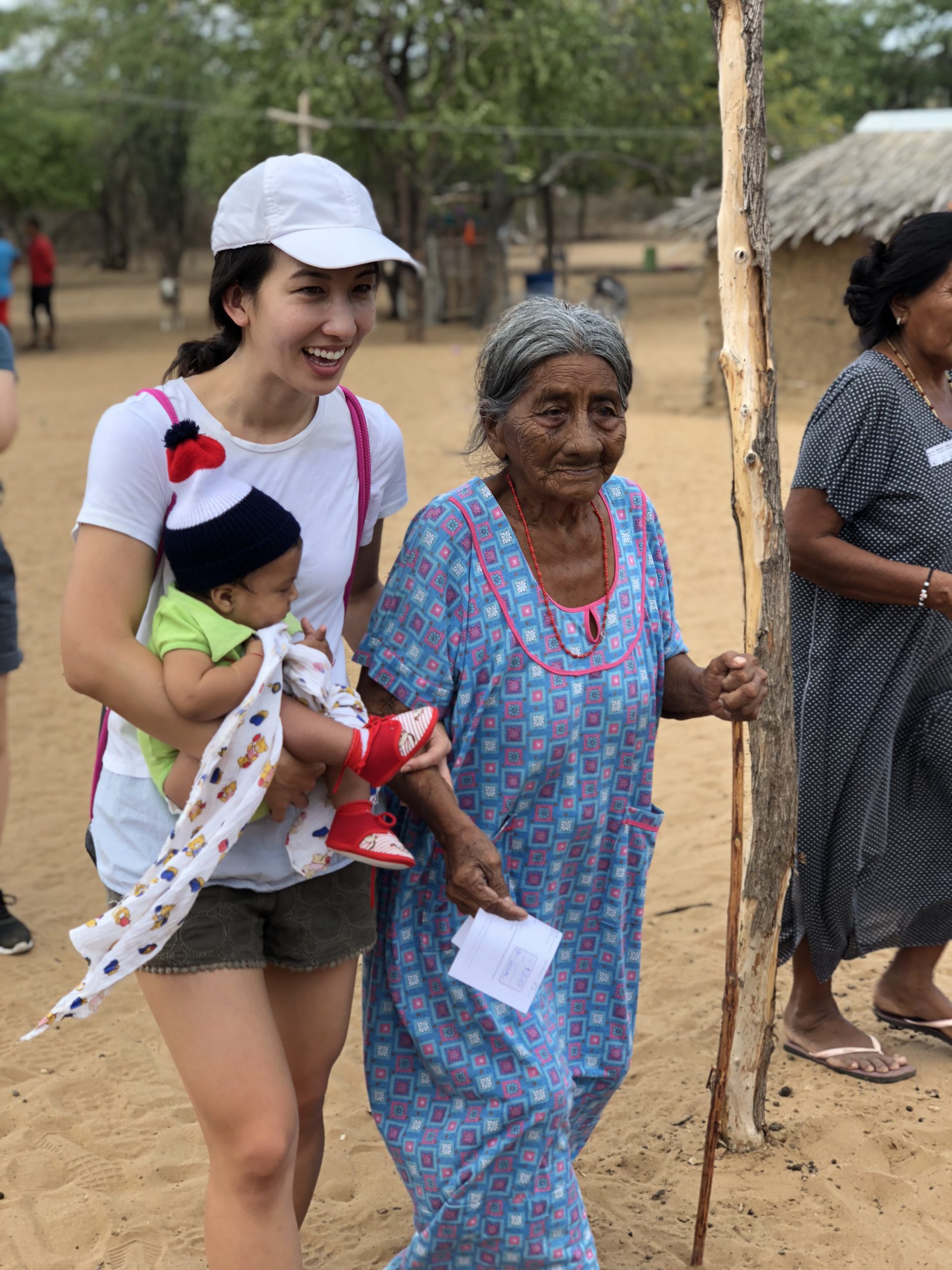 A team member of New Mercy Community Church with an elderly lady and a baby -BOH mission trip in La Guajira, Colombia.