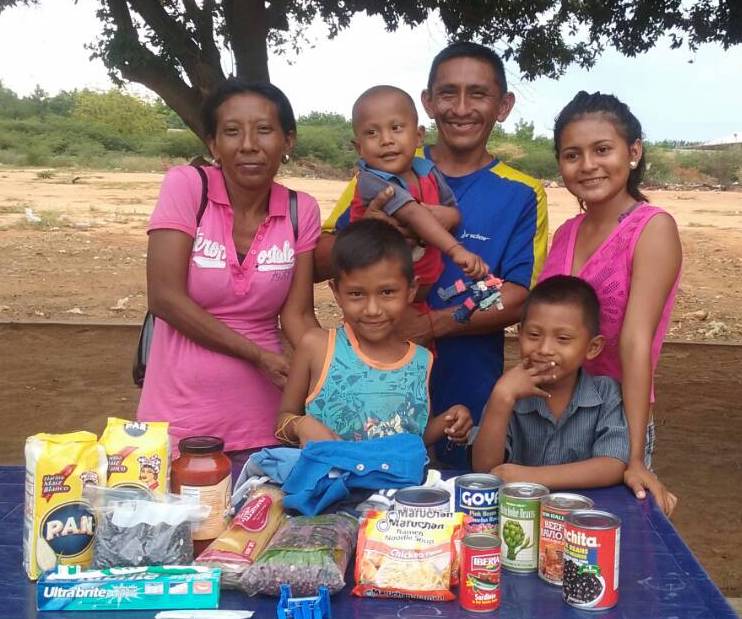 Wayuu family receiving food at Bread of Hope stand in MercaSur.