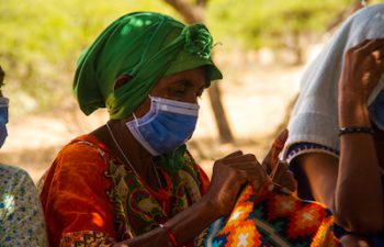 An elderly Wayuu woman wearing a protective medical mask.